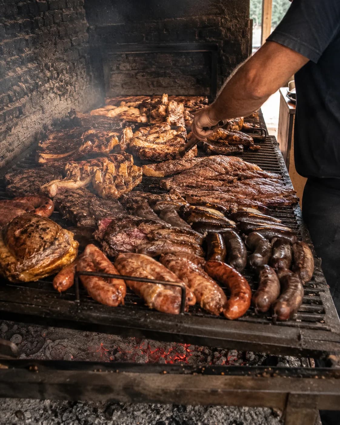 Parrilla llena de carnes, chorizos y morcillas a las brasas durante un evento de Belluno